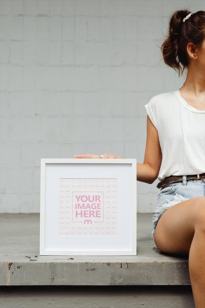 Girl Holding Picture Frame on Stairs Mockup