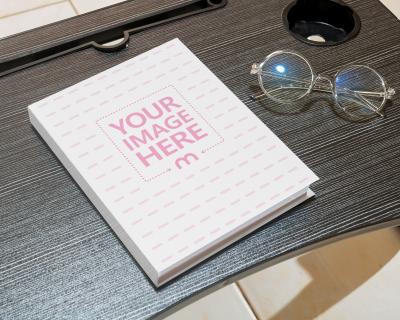 Mockup of a Hard Cover Book on a Small Black Table