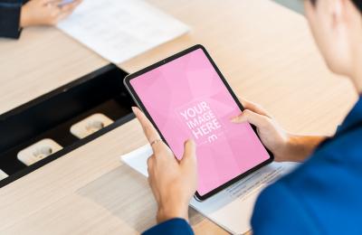 Person Holding iPad on Office Desk PSD Mockup